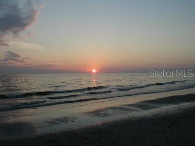 A sunset view over the ocean with waves washing onto a sandy beach — 326 BAYTREE DRIVE, ROTONDA WEST, FL