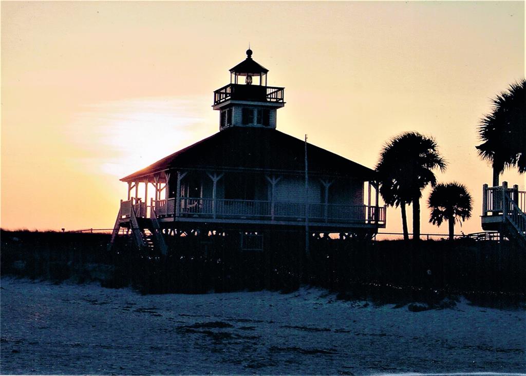 A silhouette of a beach house with a lighthouse-style cupola stands against a sunset sky — 326 BAYTREE DRIVE, ROTONDA WEST, FL