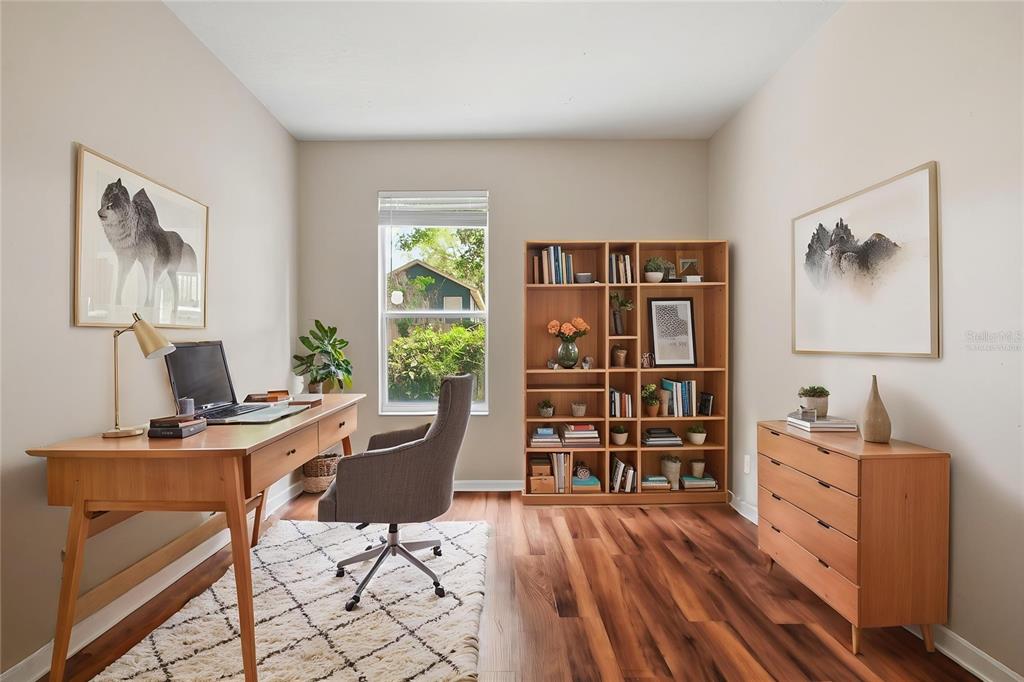 A home office with a wooden desk, bookshelf, dresser, and a window overlooking greenery — 2083 CASABA COVE AVENUE, OCOEE, FL