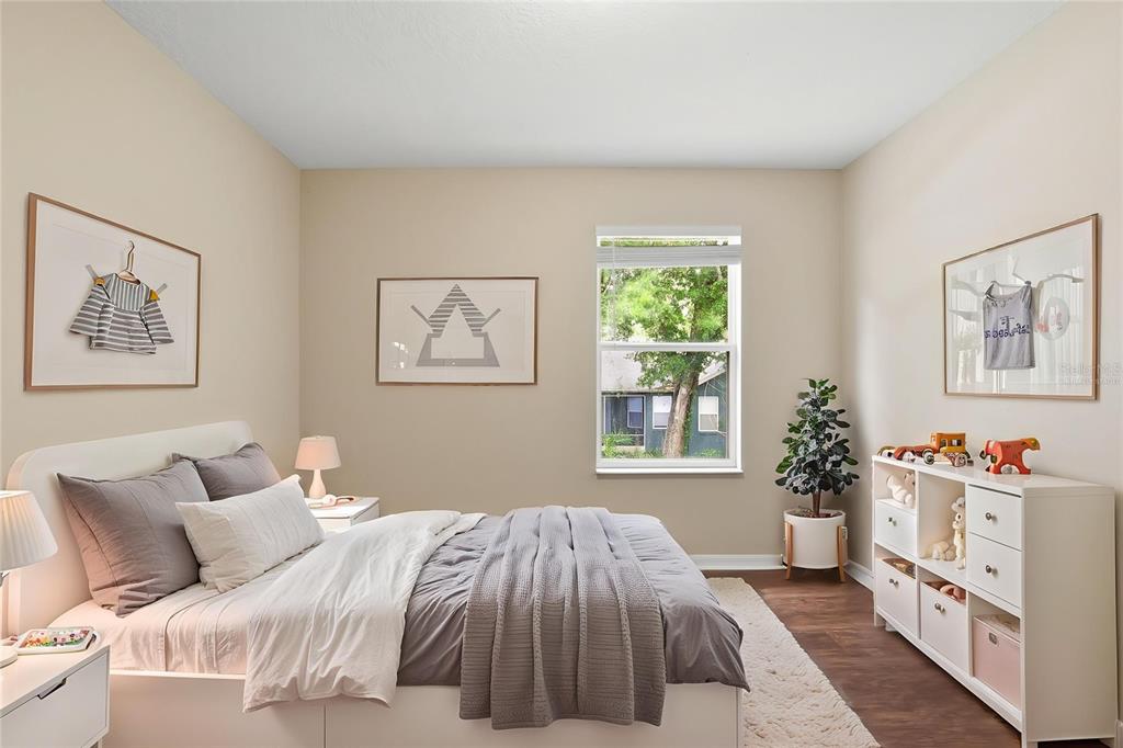 A bedroom features a bed with grey bedding, a white storage unit, and framed artwork — 2083 CASABA COVE AVENUE, OCOEE, FL
