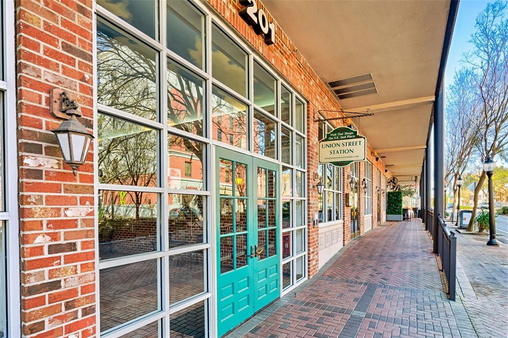 The exterior of a brick building features a ground-level storefront with teal double doors — 201 SE 2ND AVENUE UNIT 317, GAINESVILLE, FL