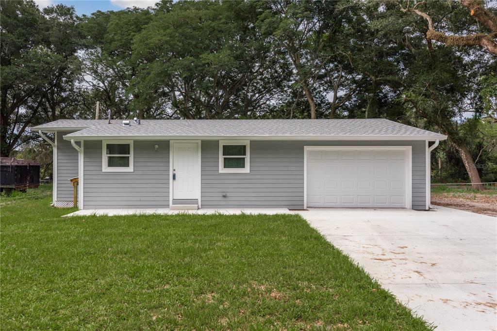 A single-story gray house with a white front door, two windows, and a one-car garage — 0 MARCHANT DRIVE, NEW PORT RICHEY, FL