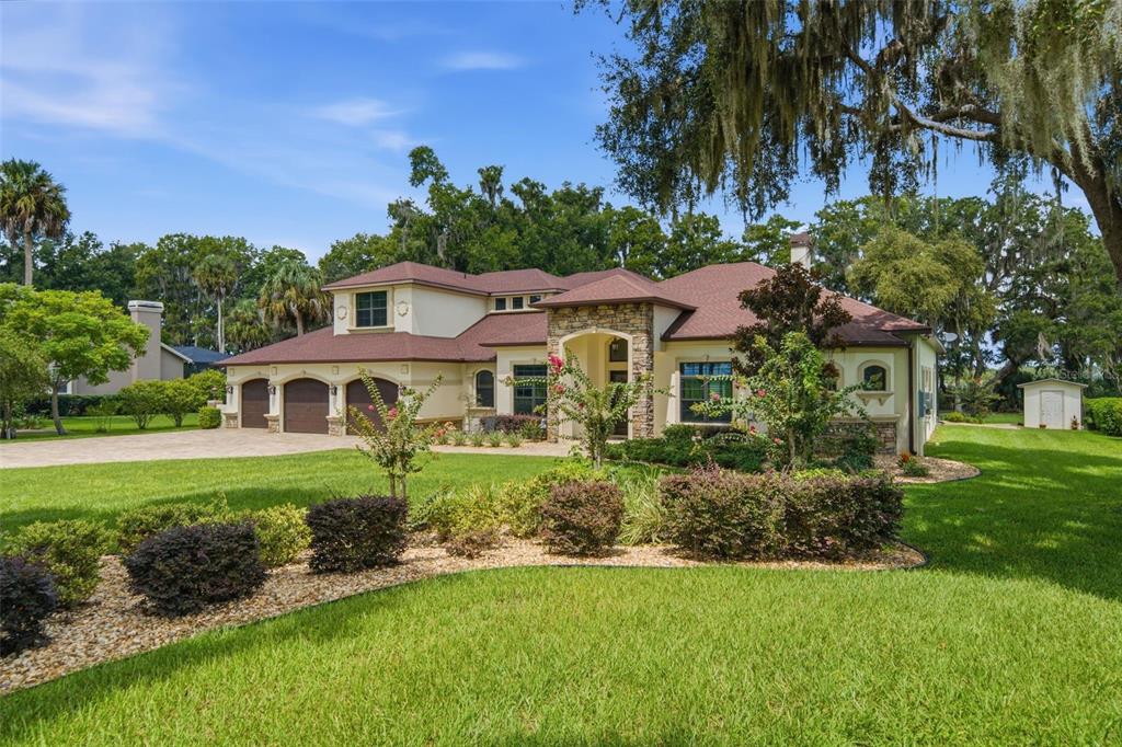 A two-story house with a stone facade, brown roof, and a three-car garage — 10994 N RIVER RANCH PATH, CRYSTAL RIVER, FL
