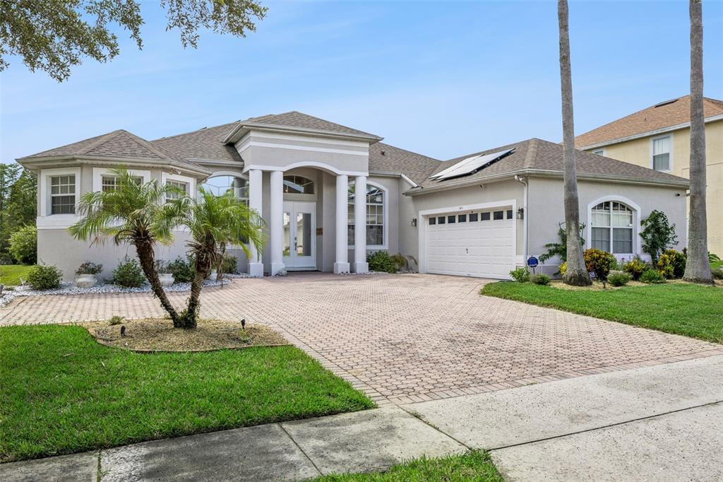 A single-story house with a paved driveway, white columns, and a two-car garage — 141 BIRKDALE STREET, DAVENPORT, FL