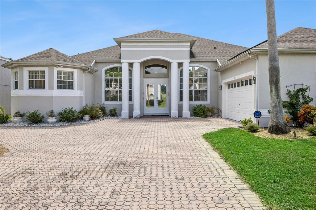 A single-story house with a paved driveway, white columns, and a double-door entrance — 141 BIRKDALE STREET, DAVENPORT, FL