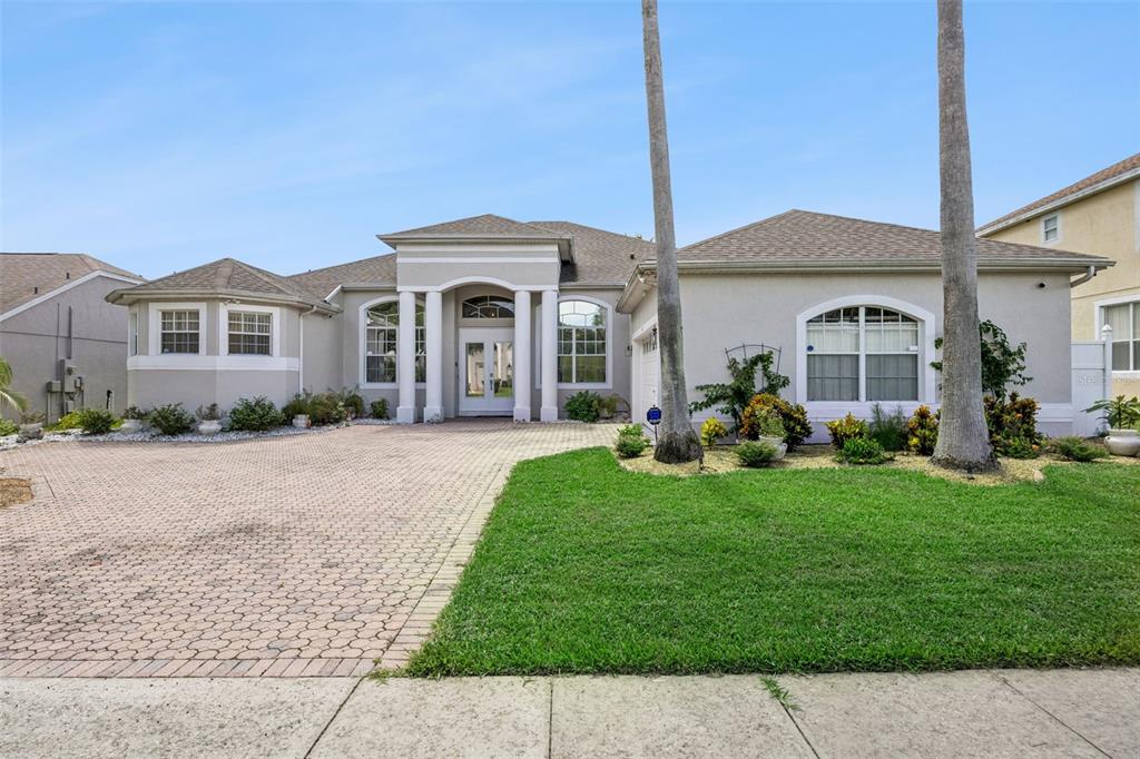 A single-story house with a paved driveway, palm trees, and a covered front entryway — 141 BIRKDALE STREET, DAVENPORT, FL