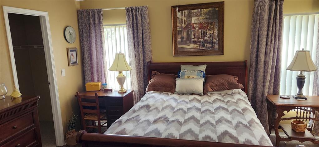 A bedroom features a wooden bed frame, two side tables with lamps, and patterned curtains — 36330 LE SABRE WAY, ZEPHYRHILLS, FL