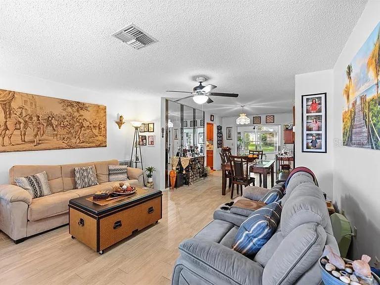 A living room features a beige sofa, a storage coffee table, and a gray recliner — 11404 STANSBERRY DRIVE, PORT RICHEY, FL