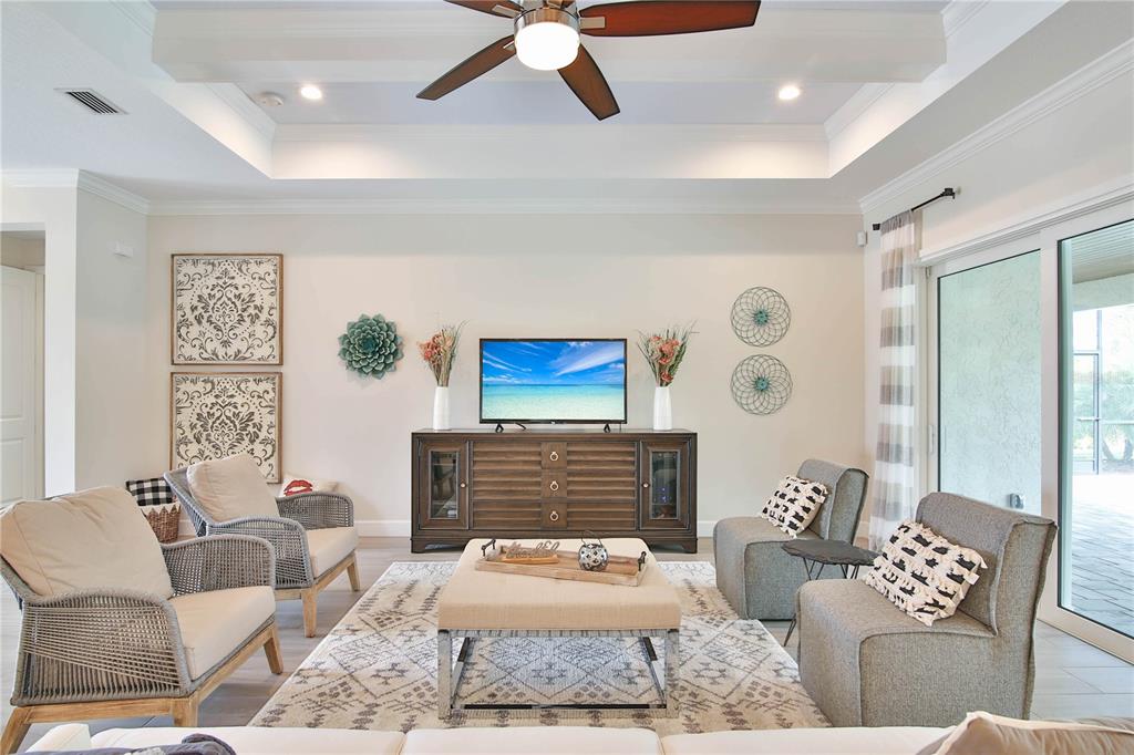 A modern kitchen features white cabinetry, a marble-patterned island, and stainless steel appliances — 7808 34TH COURT E, SARASOTA, FL