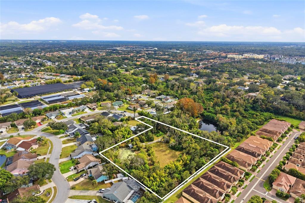 A modern kitchen features white cabinetry, a large marble island, and stainless steel appliances — 7808 34TH COURT E, SARASOTA, FL