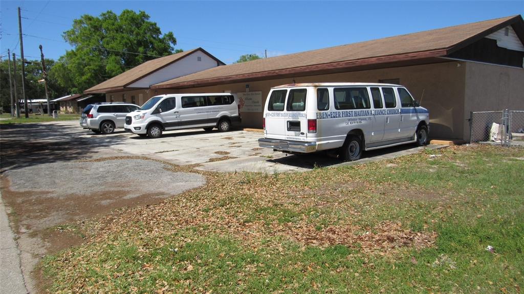 An exterior view of a church building with three vehicles parked on a concrete lot — 0 MELTON AVENUE, AUBURNDALE, FL