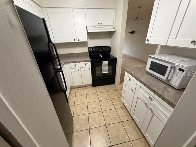 A kitchen features white cabinets, a white refrigerator, a double sink, and an adjacent laundry area — 3952 ELVIRA COURT, NEW PORT RICHEY, FL