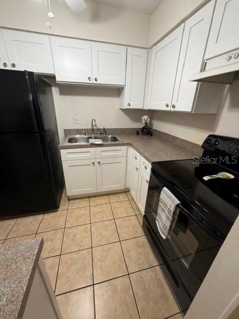 An interior view shows a tiled living area leading to an open kitchen and exterior door — 3952 ELVIRA COURT, NEW PORT RICHEY, FL