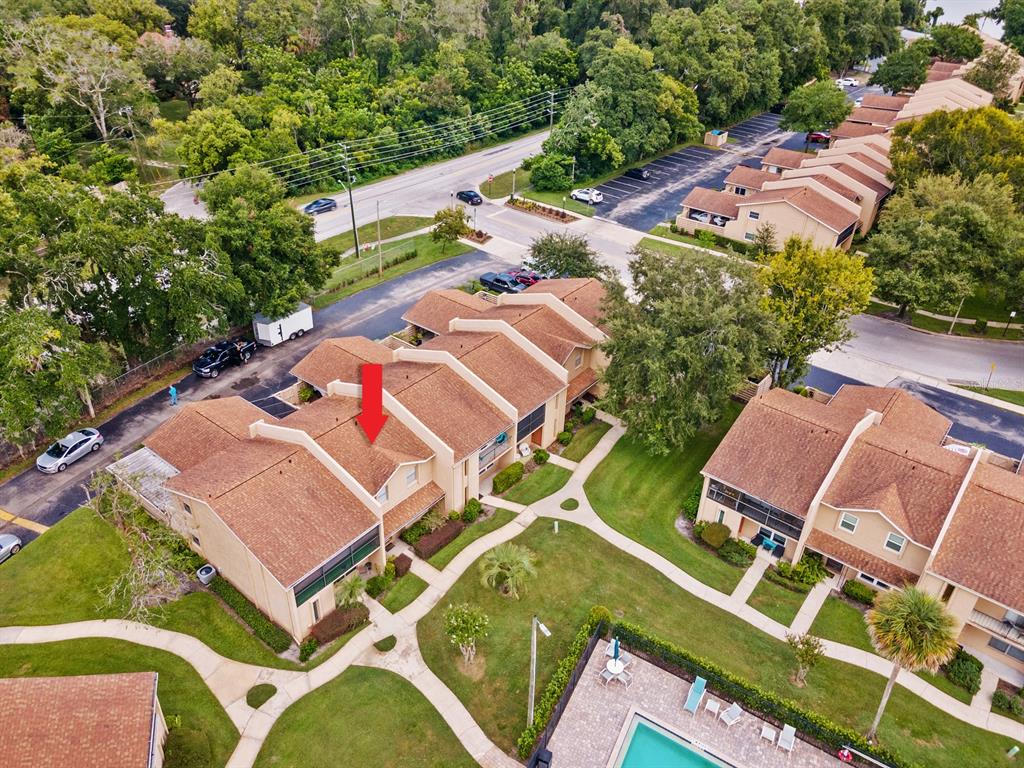 An aerial view shows a multi-unit townhouse complex with a red arrow pointing to a roof — 856 PARK LAKE CIRCLE UNIT 51, MAITLAND, FL