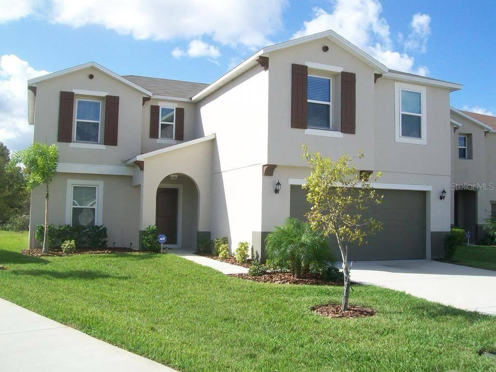 A two-story suburban house with a beige stucco exterior, brown shutters, and a two-car garage — 4752 BLUE DIAMOND STREET, KISSIMMEE, FL
