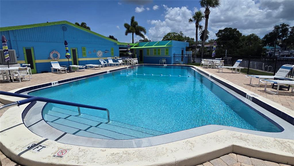 A waterfront property features a concrete seawall, a boat dock, and a grassy lawn — 9 YAWL LANE UNIT 9, PALM HARBOR, FL