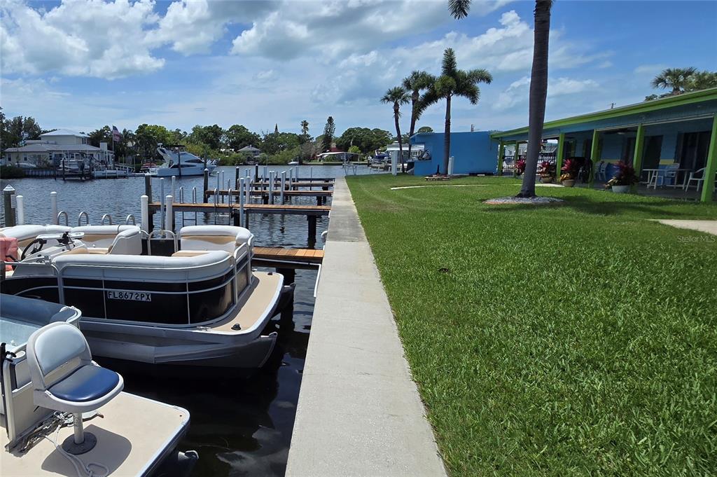 A blue and lime green clubhouse building features a brick walkway and palm trees — 9 YAWL LANE UNIT 9, PALM HARBOR, FL