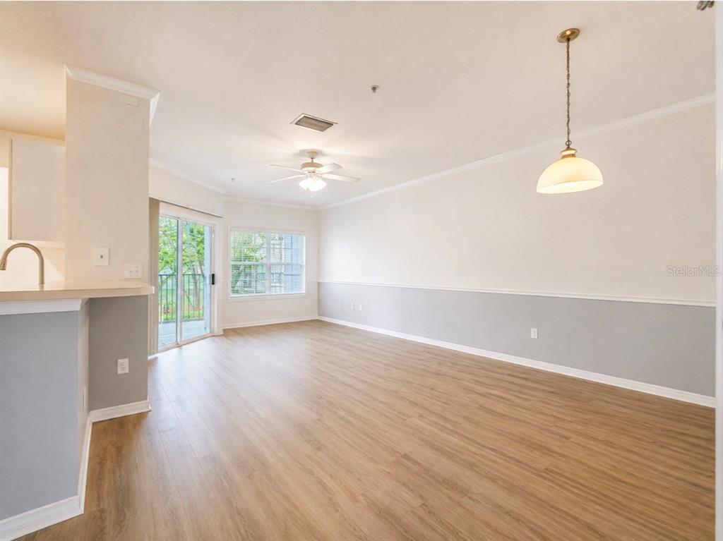 A multi-story apartment building exterior features blue stucco walls, white columns, and arched ground-level entryways — 3589 CONROY ROAD UNIT 1023, ORLANDO, FL