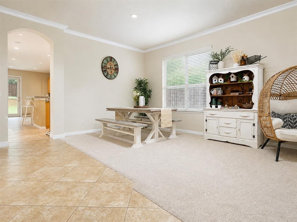 A dining area features a wooden table with benches, a white hutch, and a hanging chair — 10205 CYPRESS VINE DRIVE, ORLANDO, FL