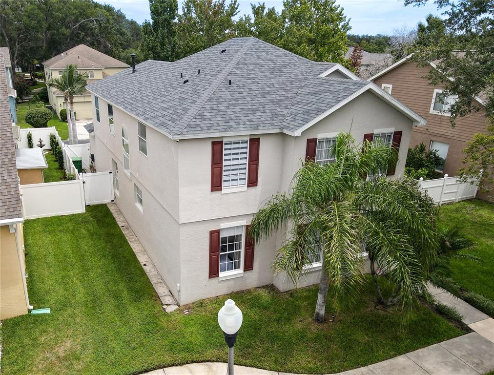 An aerial view of a two-story beige house with red shutters and a palm tree — 644 AUTUMN OAKS LOOP, WINTER GARDEN, FL