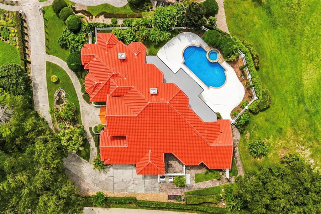 An aerial view shows a large house with a red tile roof and a swimming pool — 1036 GOLF VALLEY DRIVE, APOPKA, FL