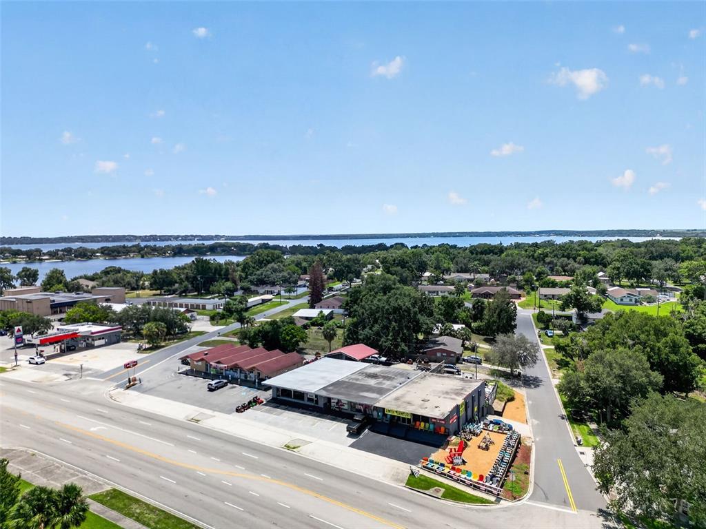 An aerial view shows a commercial building with a parking lot near a lake — 1035 W HIGHWAY 50 HIGHWAY, CLERMONT, FL