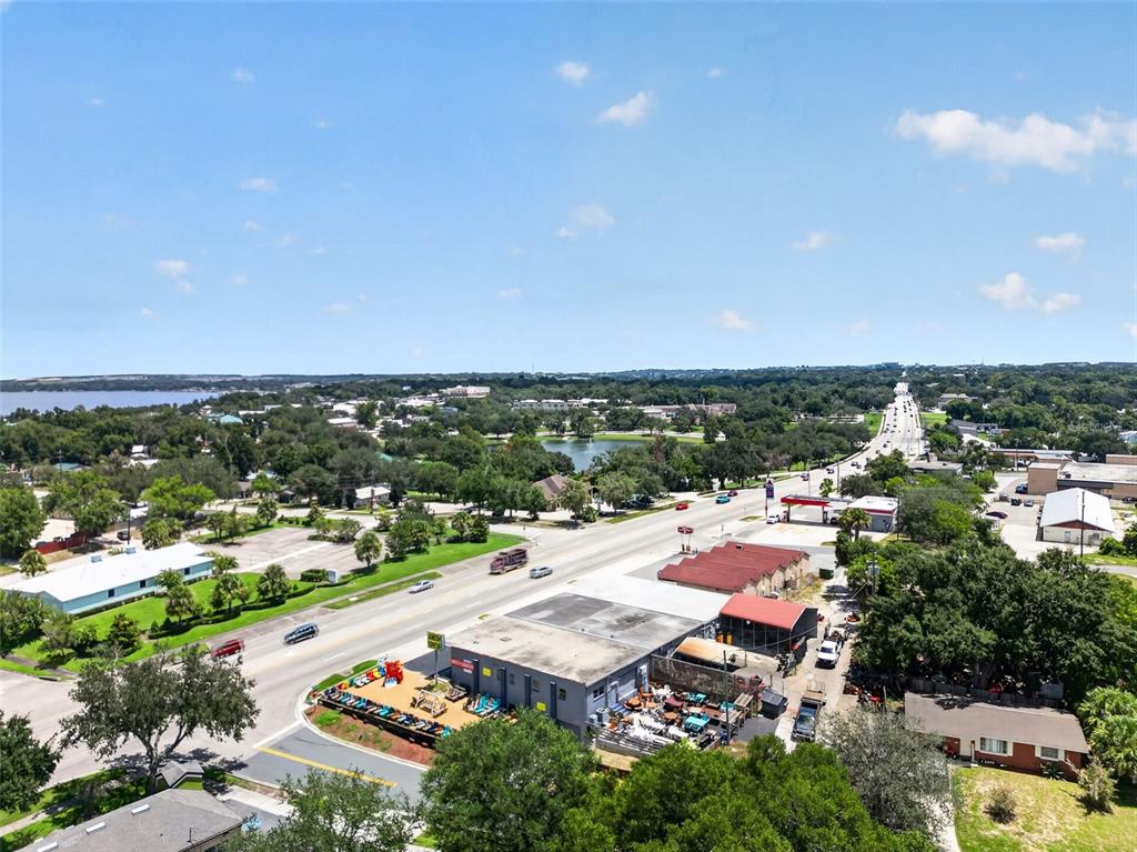 An aerial view shows a commercial building with outdoor storage alongside a road and trees — 1035 W HIGHWAY 50 HIGHWAY, CLERMONT, FL