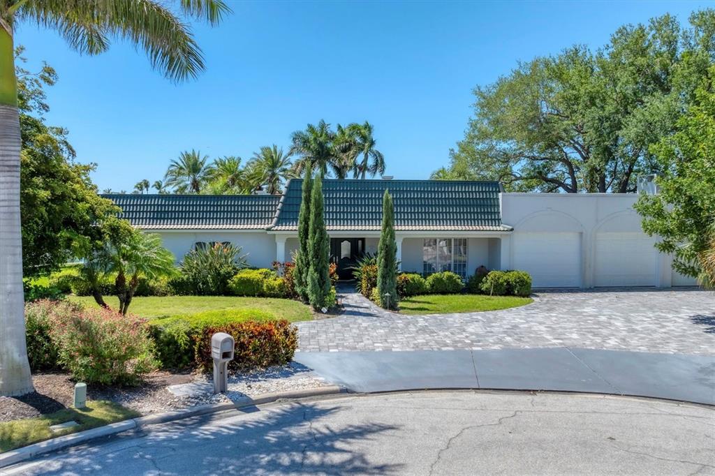 A single-story house with a green tiled roof, white exterior, and a paved driveway — 102 SEAGULL LANE, SARASOTA, FL