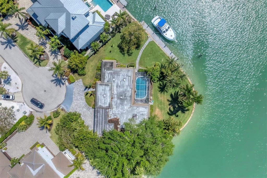 An aerial view shows a waterfront house with a pool, dock, and boat — 102 SEAGULL LANE, SARASOTA, FL