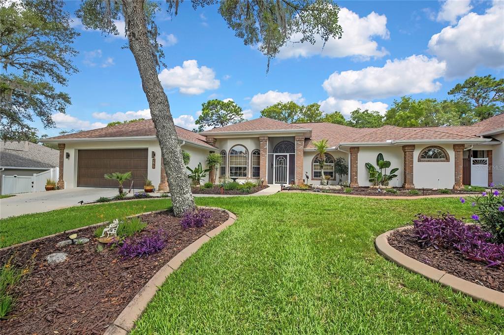 An aerial view of a single-story house with a brown roof and landscaped front yard — 5701 W CHIVE LOOP, HOMOSASSA, FL