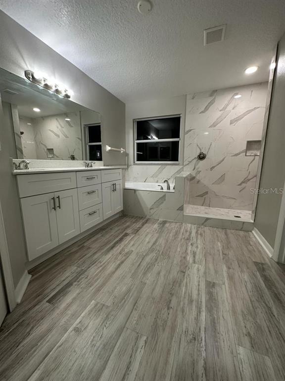 A bathroom features a double vanity, a soaking tub, and a walk-in tiled shower — 4743 CHALFONT DRIVE, ORLANDO, FL