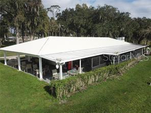 An aerial view of a house with a large white metal roof and a screened-in porch — 153 FERN DRIVE, DEBARY, FL