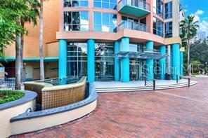 The exterior of a multi-story building features teal columns, a brick plaza, and a fountain — 322 E CENTRAL BLVD UNIT 1807, ORLANDO, FL