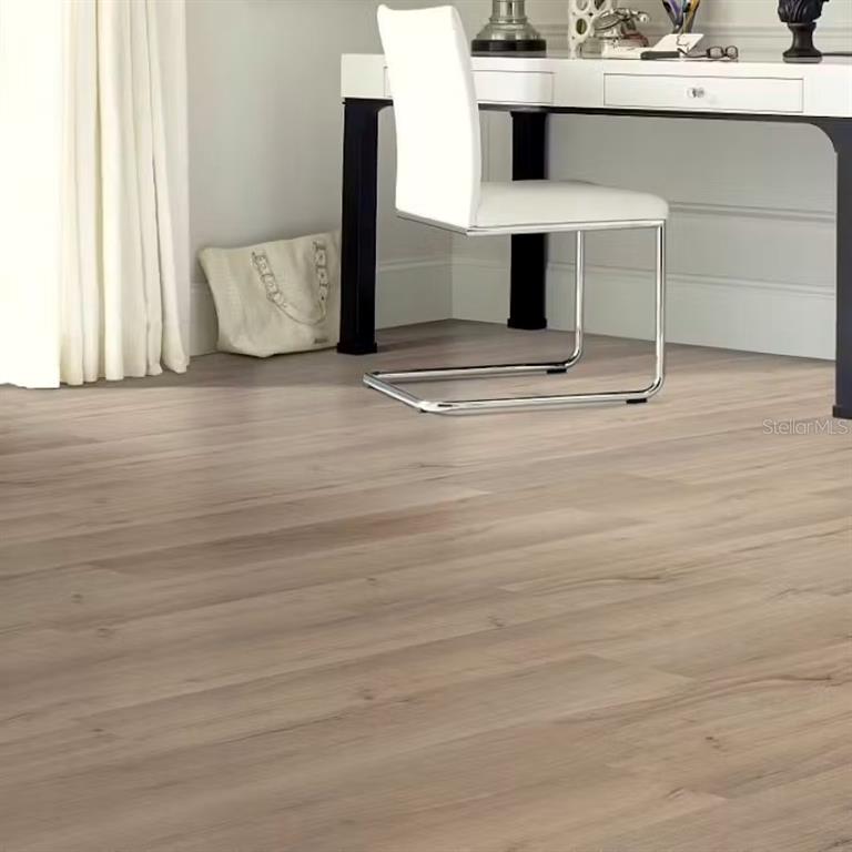 A white desk and chair sit on light-colored wood-look flooring in a bright room — 7636 SW 6TH LOOP, OCALA, FL