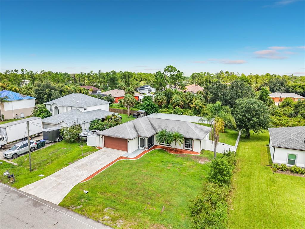 An aerial view shows a single-story house with a concrete driveway and a fenced yard — 2198 ALLIANCE AVENUE, NORTH PORT, FL