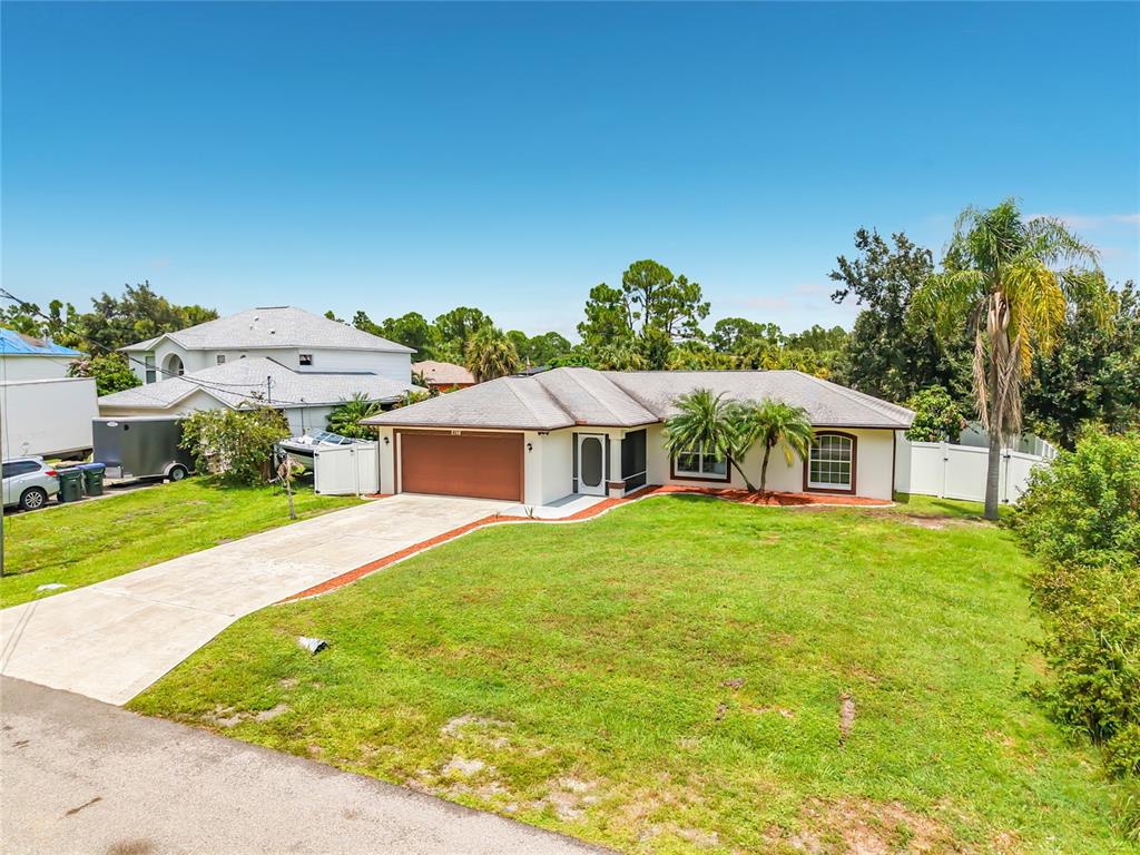 A single-story house with a brown garage door, light-colored exterior, and a large front lawn — 2198 ALLIANCE AVENUE, NORTH PORT, FL