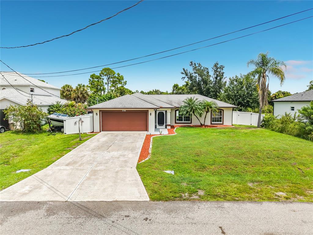 A single-story house with a brown garage door, concrete driveway, and a grassy front yard — 2198 ALLIANCE AVENUE, NORTH PORT, FL