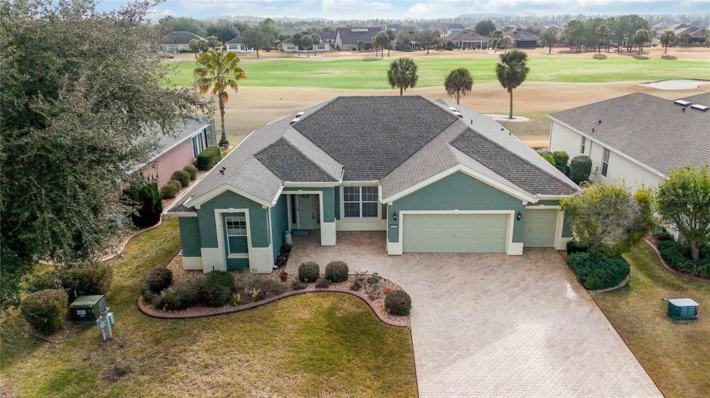 An aerial view of a teal single-story house with a paved driveway and golf course view — 9439 SW 71ST LOOP, OCALA, FL