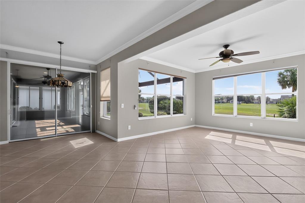 A spacious room with tile flooring, large windows, a ceiling fan, and a sliding glass door — 9439 SW 71ST LOOP, OCALA, FL