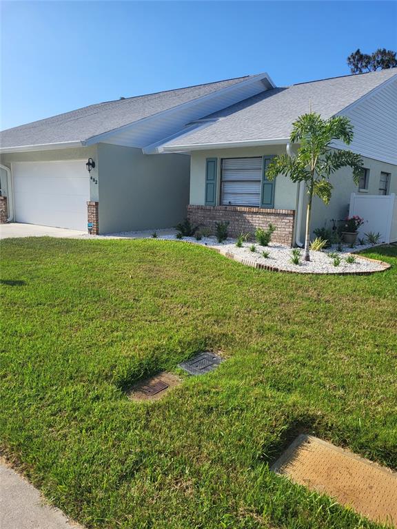 A single-story house with a white garage, light green siding, and a landscaped front yard — 482 PENDLETON PLACE, VENICE, FL