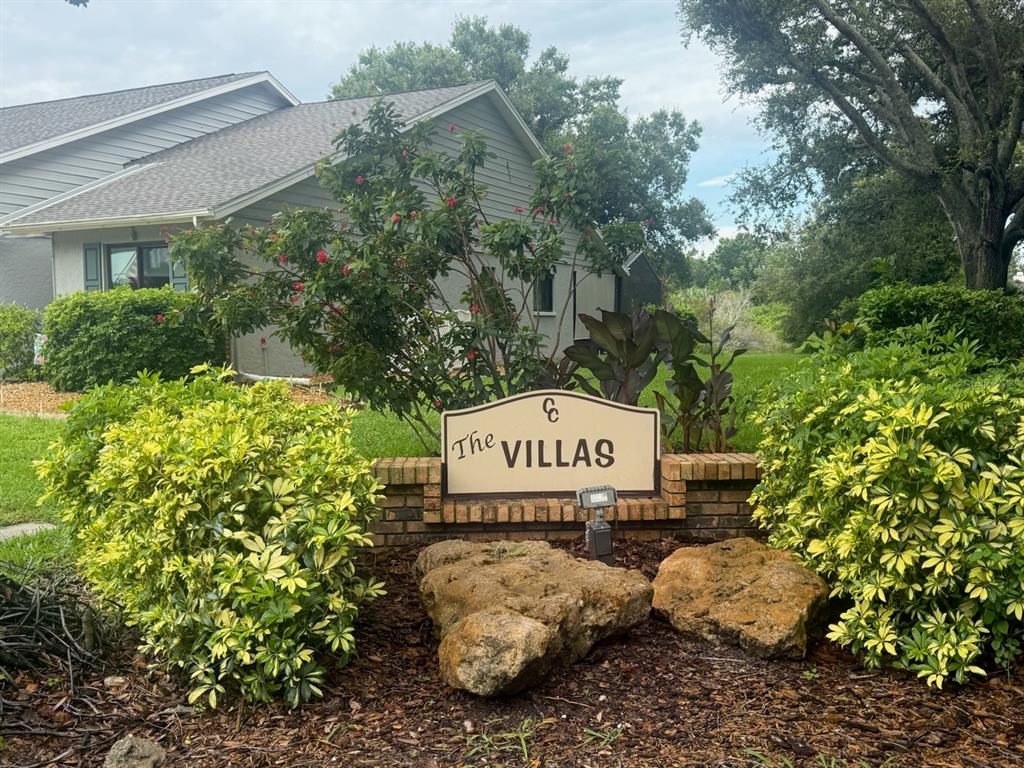 A sign reading The Villas stands in front of a house surrounded by landscaping — 482 PENDLETON PLACE, VENICE, FL