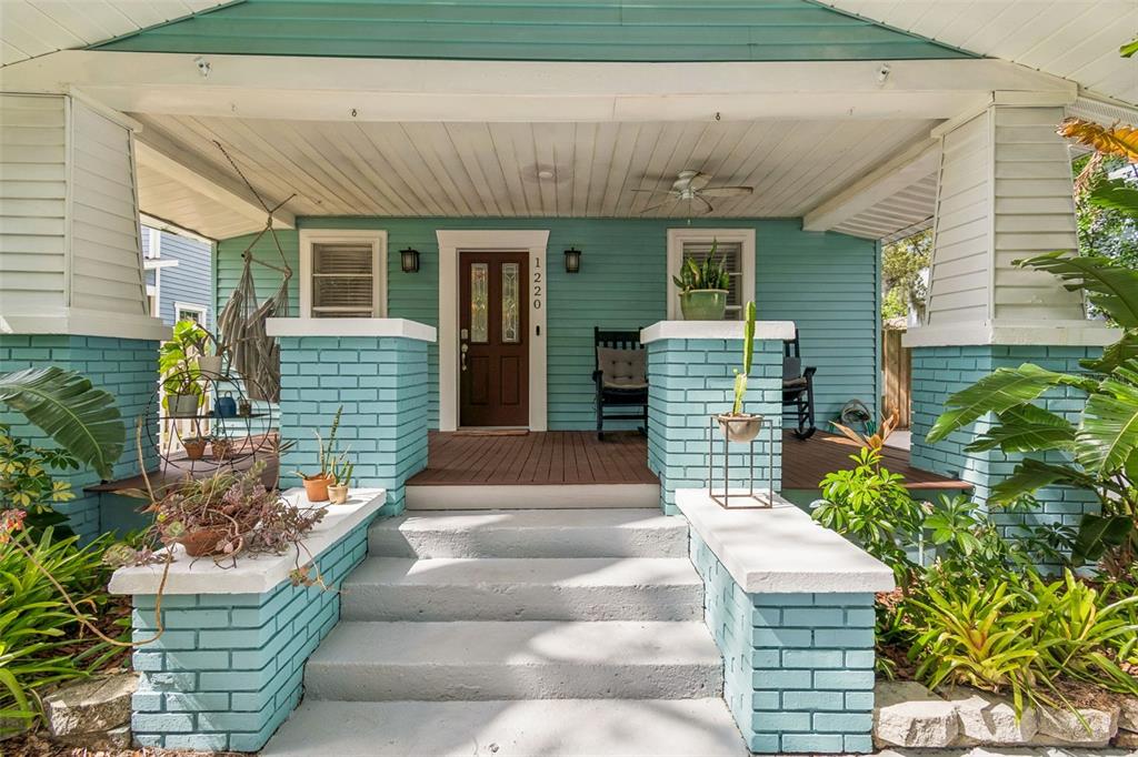 A covered front porch features light blue siding, a brown door, and two rocking chairs — 1220 E EMMA STREET, TAMPA, FL