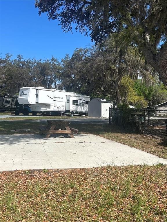 A black pickup truck is parked in front of a Columbus fifth-wheel trailer at a campsite — 15991 NE 243RD PLACE ROAD UNIT 54, FORT MC COY, FL