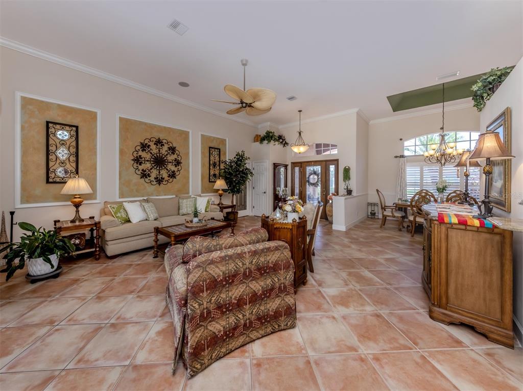 A spacious living and dining area features tile flooring, neutral walls, and a ceiling fan — 148 WADING BIRD DRIVE, VENICE, FL