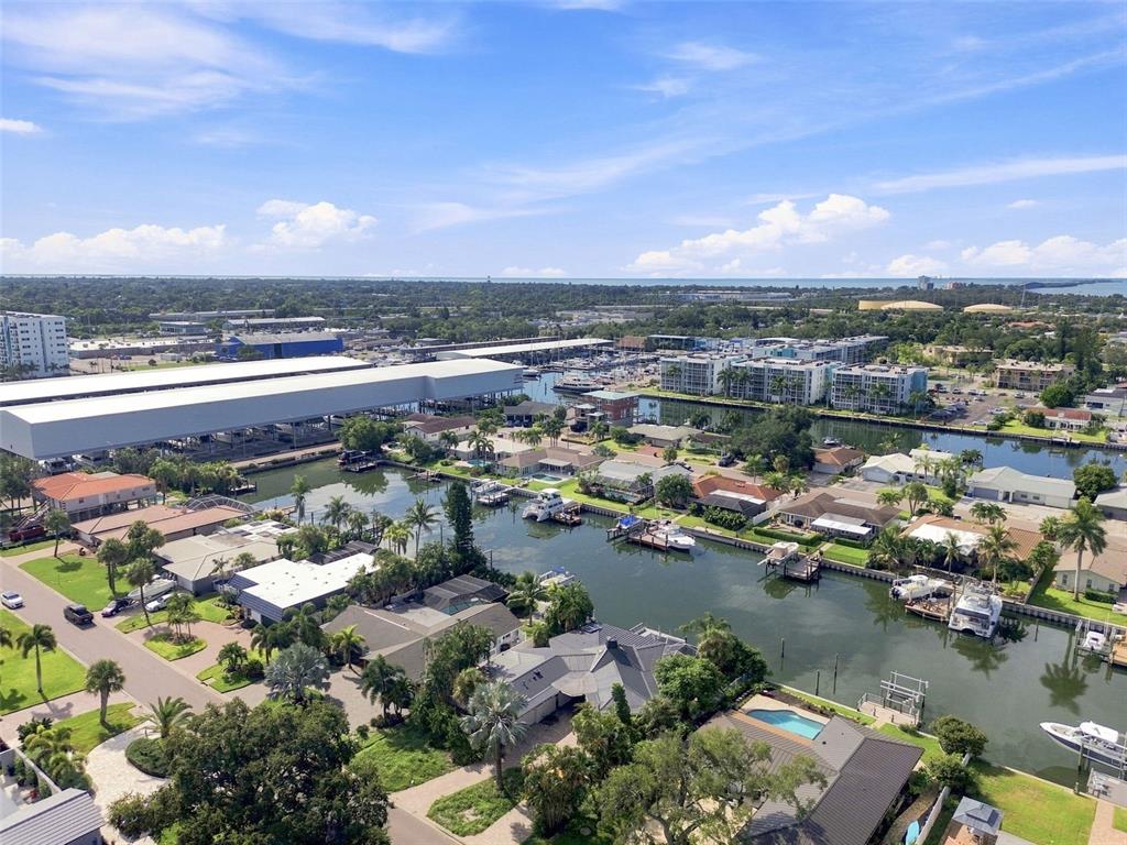 An aerial view shows a residential neighborhood with canals, boat docks, and a large warehouse — 3830 46TH AVENUE S, ST PETERSBURG, FL