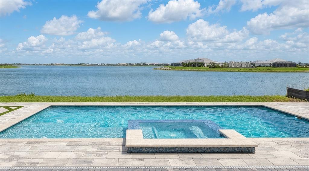A single-story house with a paved driveway, a three-car garage, and palm trees — 812 BLUE SHELL LOOP, SARASOTA, FL