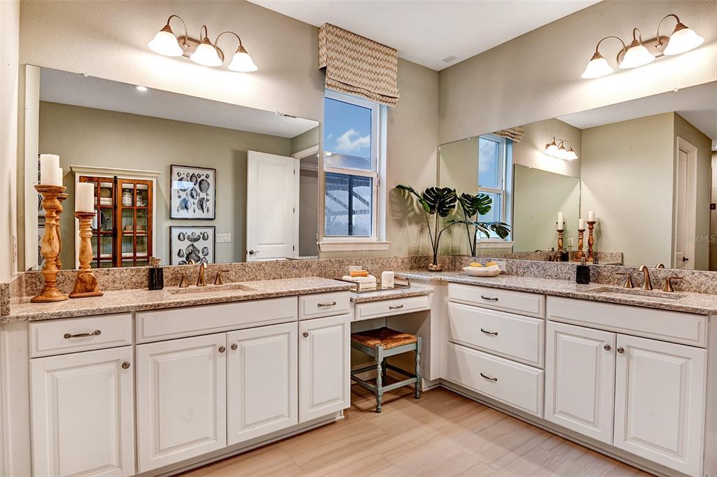 A bright kitchen features white cabinetry, a large island with seating, and blue tile backsplash — 16240 ALPHA GROVE PLACE, ODESSA, FL