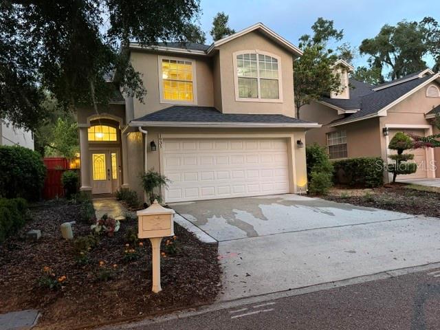 A two-story house with a beige exterior, a two-car garage, and a front driveway — 1931 LOST SPRING COURT, LONGWOOD, FL