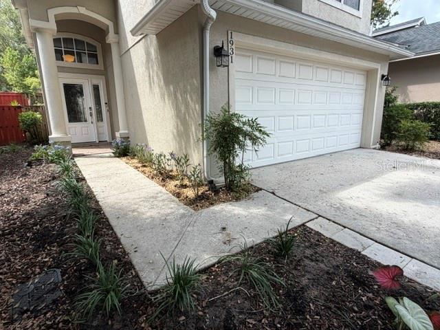 A concrete walkway leads to the front door and garage of a suburban house — 1931 LOST SPRING COURT, LONGWOOD, FL