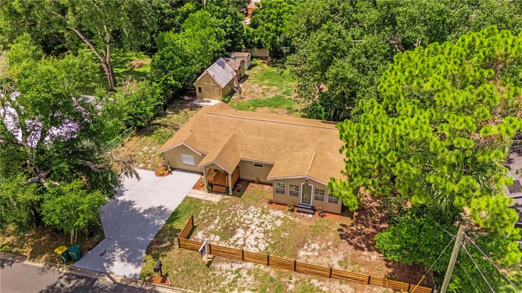 An aerial view shows a single-story house with a brown roof, concrete driveway, and detached shed — 305 S ROSSITER STREET, MOUNT DORA, FL